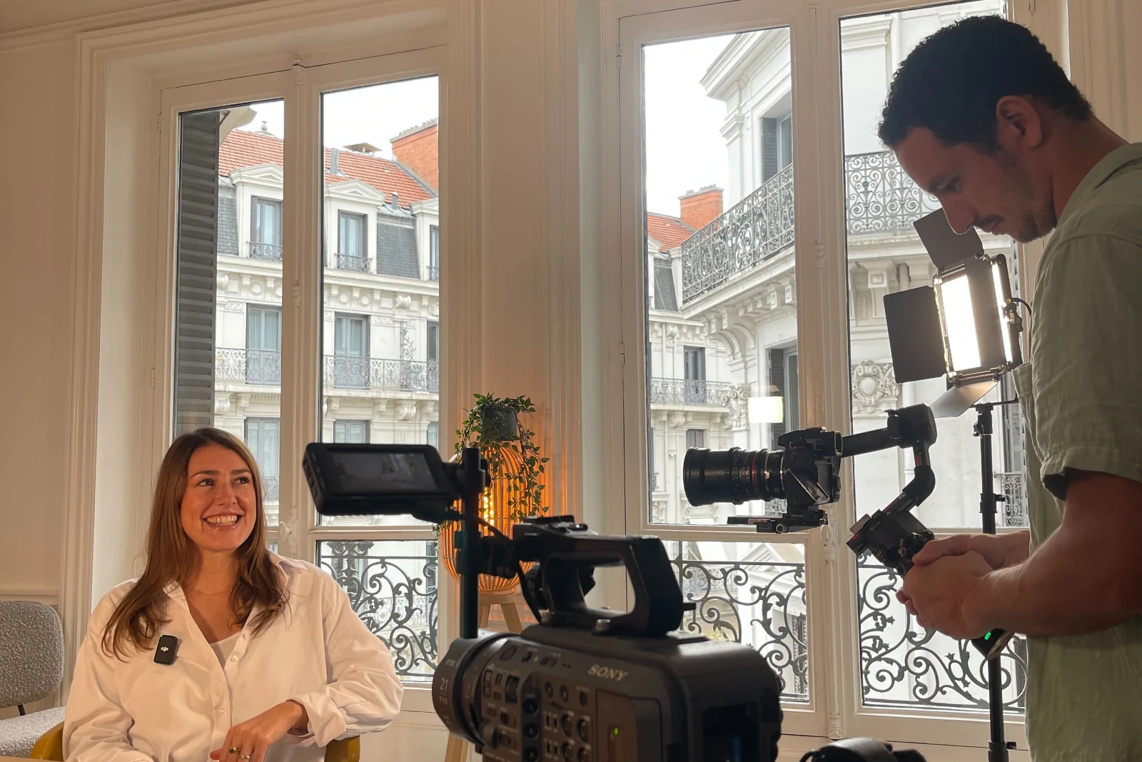 Un tournage d’interview : la caméra sur trépied, un stabilisateur, les fenêtres d’un appartement lyonnais